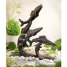 a sculpture of fish in the middle of some rocks