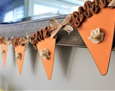 an orange bunting banner hanging from the side of a wall with pine cones on it