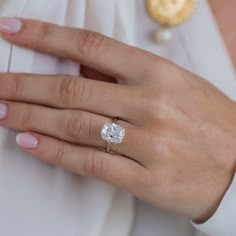 a woman's hand with a diamond ring on it