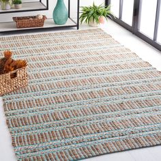 a large rug in the middle of a room with plants and other items on the floor