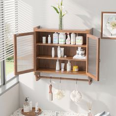 an open medicine cabinet in the corner of a bathroom with flowers and other personal care items