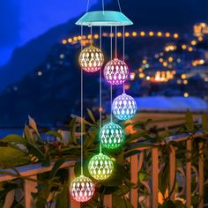 multicolored lights hanging from the side of a balcony