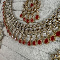 Beautifully flexible Antique Gold intricate necklace set scattered with dazzling clear zircon crystals and red drops. Comes with matching earrings (approx 2.5 inch length x 1.5 inch width) and matching tikka ( pendant part 2 inch length x 1.5 inch width)  Ready to ship as seen with gift box! Red Ruby Drop Jewelry, Festive Crystal Jewelry Sets With Stone Work, Red Hand Set Kundan Necklace, Red Stone Setting Bridal Necklace As Gift, Red Cubic Zirconia Jewelry Sets For Festive Occasions, Red Jeweled Jewelry In Cubic Zirconia, Red Cubic Zirconia Jewelry With Stones, Red Jeweled Cubic Zirconia Jewelry, Traditional Red Jewelry Sets With Stones