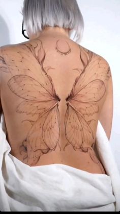 the back of a woman's body with butterfly tattoos on it