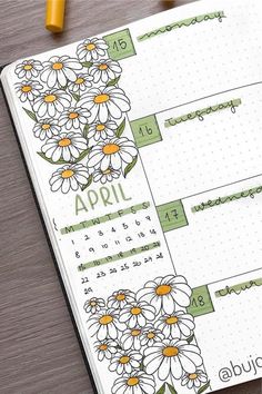 an open planner with daisies on it and the words april written in cursive writing