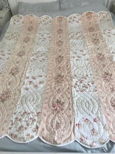 a bed with a white and pink bedspread on top of it