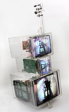 three televisions stacked on top of each other in acrylic boxes with wires attached to them