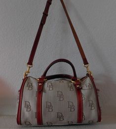 "Canvas crossbody/satchel Canvas has four tone color: beige, gold, brown and light blue Logo in brown Red leather trim, strap and tassel and handle Zipper closure with tassel Gold hardware Adjustable strap Front layout: two side open pockets, a compartment with red leather flap and snap Interior layout: a key chain, one zipper compartment and open pocket, two compartments on the opposite wall with snap Normal wear signs, a small cut at the bottom on back side, about 1/4\" long. See photos for qu Brown Canvas Bags With Gold-tone Hardware, Vintage Coated Canvas Satchel With Gold-tone Hardware, Canvas Satchel With Gold-tone Hardware For Travel, Brown Coated Canvas Satchel With Handle Drop, Travel Canvas Satchel With Gold-tone Hardware, Daily Use Canvas Satchel With Gold-tone Hardware, Canvas Satchel With Gold-tone Hardware, Daily Use Coated Canvas Satchel With Gold-tone Hardware, Gold-tone Coated Canvas Crossbody Satchel