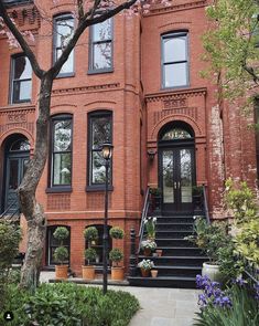 a large brick building with many windows and steps leading up to the front door area