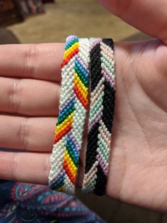 a hand holding two different colored bracelets