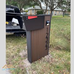 a trash can sitting in the grass next to a truck