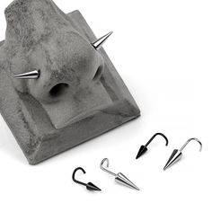 three pairs of metal hooks are attached to a concrete structure with spikes and claws on it