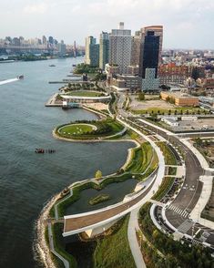 an aerial view of a city and the water with lots of green grass on it