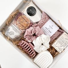 an open box containing soaps, combs, and other personal care items on a white surface