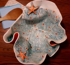 two starfish shaped dishes with spoons and napkins on a wooden table top