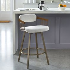 a white counter top sitting next to a wooden bar stool in a kitchen under a mirror