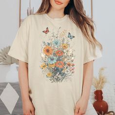 Cottagecore, fairycore and Butterflies all combine on this beautiful botanical tshirt and it could be just what you've been looking for. With it's whimsical, butterfly, botanical design, you'll love the look and feel of this shirt, in fact it could just become your fav. Comfort Colors introduces its garment-dyed t-shirt; a fully customizable tee made 100% with ring-spun cotton. The soft-washed, garment-dyed fabric brings extra coziness to your wardrobe while the relaxed fit makes it an excellent Fairycore Short Sleeve Tops For Spring, Summer Fairycore Crew Neck T-shirt, Cotton Fairycore T-shirt For Summer, Summer Fairycore Cotton T-shirt, Spring Cottagecore Shirt With Graphic Print, Spring Fairycore Crew Neck T-shirt, Cottagecore Printed T-shirt With Relaxed Fit, Cottagecore Summer T-shirt With Plant Print, Spring Fairycore Graphic Print T-shirt