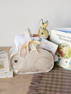 A fabric basic in the shape of a large fluffy bunny, hunched over with its ears sticking up. A light brown and pink embroidered to define the texture and facial details of the body and face. This picture has the basket holding different items such as books, flowers, and stuffed animals. Zero Waste Easter Basket, Baby Valentines Basket, Newborn Easter Basket, 2024 Watercolor, Coral And Tusk, Rabbit Design, Bunny Basket, Baby Chicks, New Mothers