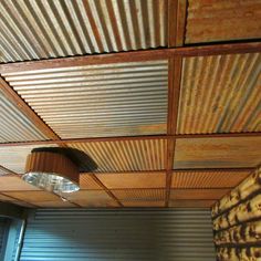 the ceiling is made out of corrugated sheets and has a lamp hanging from it's side