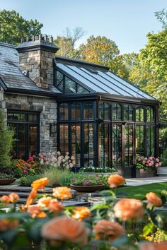 an orange flower garden in front of a house with glass walls and windows on the roof