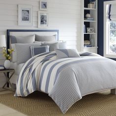 a bedroom with blue walls and white bedding