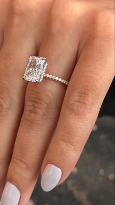 a woman's hand with a ring on it and a diamond in the middle