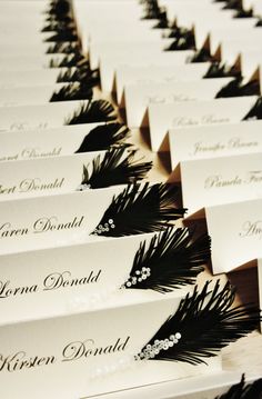 many cards with black and white feathers on them are lined up next to each other