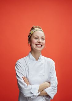 a woman wearing a chef's coat with her arms crossed