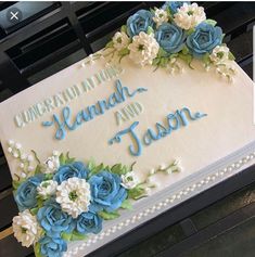 a cake with blue and white flowers on it that says congratulations hand and tason