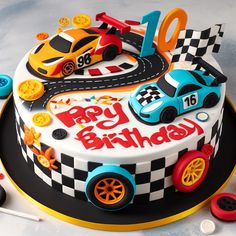 a birthday cake decorated with racing cars and numbers