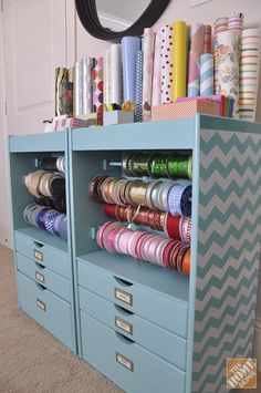 an organized craft room with lots of different colored items on the shelves and paper rolls