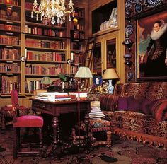 a living room filled with lots of furniture and bookshelves next to a chandelier