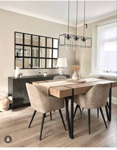 a dining room table and chairs in front of a window with mirrors on the wall