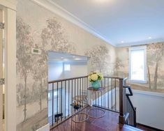 the stairs are decorated with wallpaper and wood flooring, along with a vase of flowers