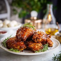 some food on a white plate with sauce and sprig of rosemary next to it