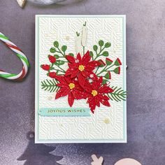 a christmas card with poinsettis on it next to some candy canes