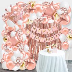 a birthday party with balloons, streamers and pink and white decorations on the wall