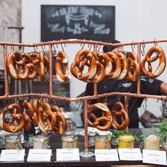 several pretzels are on display in front of a man behind a counter at a restaurant