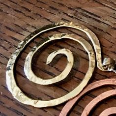 This large spiral pendant is inspired by the graceful spirals of the nautilus. Each spiral is hand-shaped and hammered with the signature texture from my antique anvil. The texture comes from years of history, and every nick, dent and cranny is transferred to the metal by hammer stroke.Great for everyday wear, this spiral pendant hangs from a delicate sterling chain with spring clasp and daisy loop giving it that extra little detail. A perfect gift for you, a friend or a loved one. The size of t Hammered Brass Spiral Jewelry, Unique Hammered Spiral Jewelry, Electroformed Spiral Metal Jewelry, Spiral Electroformed Metal Jewelry, Spiral Copper Necklace In Gold Color, Spiral Brass Jewelry, Gold Spiral Necklace In Copper, The Nautilus, Spiral Pendant