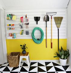 a yellow and white room with black and white checkered flooring, potted plants and gardening tools on the wall