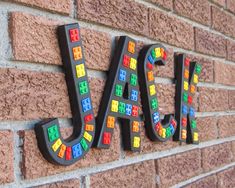 the word jack spelled in multicolored letters on a brick wall with magnets