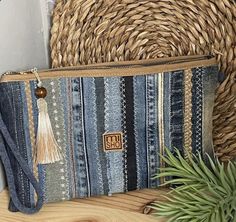 a blue and white striped purse sitting on top of a wooden table next to a plant