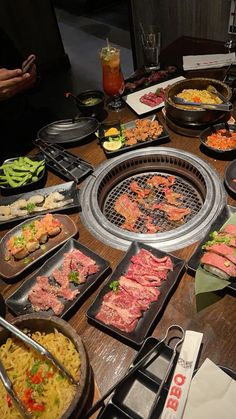 a table full of food and utensils on it, including meat skewers