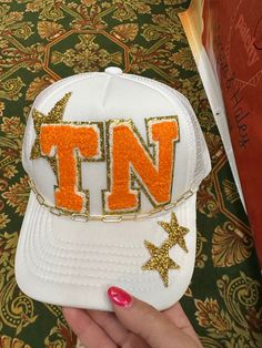 White trucker hat with TN iron on patches and chain Iron On Patches Ideas, Cap Inspiration, Bling Hats, Boutique Store Displays, Craft Nights, White Trucker Hat, Sports Team Apparel, Hat Bar, Patch Ideas