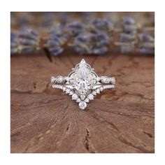 an engagement ring on top of a piece of wood with lavenders in the background