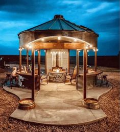 an outdoor gazebo with lights on the top and side walls is lit up at night