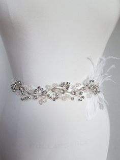 "This unique beautiful belt is made with Swarovski crystals, cultured freshwater pearls and antiqued silver appliqued on a 1\" grosgrain ribbon. It has a delicate feather detail on the side of the belt and swirly vine design that wraps along the front of your waist line. The embellished part of the belt measures about 11\" long and the entire sash measures 150\" long. Available in antique silver, silver or gold finish. - Shown here in antiqued silver finish and with off white ribbon" Elegant Silver Embroidered Belt, Elegant Beaded Silver Sashes, Elegant Silver Beaded Sash, Outfit Boda, Feather Belt, Wedding Belt, Crystal Belt, Wedding Sash Belt, Beautiful Belts