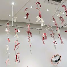 red and white streamers hanging from the ceiling in an art gallery with mirrors on the wall