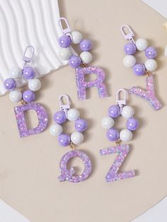 the letters are decorated with purple and white beads