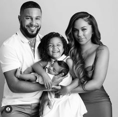 a man, woman and child posing for a black and white photo with their arms around each other